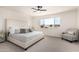 Comfortable bedroom with neutral tones, large window, ceiling fan, and a cozy seating area provides relaxation at 15619 N 30Th Ave, Phoenix, AZ 85053