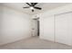 Neutral bedroom featuring a ceiling fan and a double-door closet for storage at 15619 N 30Th Ave, Phoenix, AZ 85053