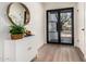 Welcoming foyer featuring a modern cabinet, decorative mirror, and front door at 15619 N 30Th Ave, Phoenix, AZ 85053