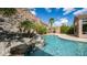 Backyard with a pool featuring a rock waterfall and mature palm trees against a scenic hillside at 16060 S 4Th St, Phoenix, AZ 85048