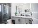 A modern bathroom features an illuminated mirror, gray cabinetry and a glass shower at 16060 S 4Th St, Phoenix, AZ 85048