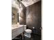 Modern powder room with a marble sink, pendant lighting, black herringbone floors, and textured wallpaper at 16060 S 4Th St, Phoenix, AZ 85048