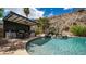 Backyard oasis with sparkling pool, rock waterfall, outdoor kitchen, and landscaped grounds at 16060 S 4Th St, Phoenix, AZ 85048