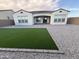 Home backyard with artificial turf and desert rock landscaping at 17019 W Cameron Dr, Surprise, AZ 85388