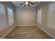 Bright bedroom with wood floors features plantation shutters and ceiling fan at 17019 W Cameron Dr, Surprise, AZ 85388