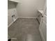 Functional laundry room with tile flooring, sink, and storage at 17019 W Cameron Dr, Surprise, AZ 85388