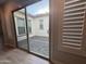 View of courtyard through glass doors, light floors, and shuttered windows at 17019 W Cameron Dr, Surprise, AZ 85388