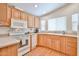 Bright kitchen featuring modern white appliances, light wood cabinets, and a functional layout at 17200 W Bell Rd # 1185, Surprise, AZ 85374