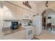 Bright kitchen showcases granite countertops, white appliances, and views through an arched doorway into a dining area at 18932 N 89Th Way, Scottsdale, AZ 85255