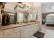 Bright bathroom with dual sinks, granite countertops, decorative mirrors, and access to the main bedroom at 18932 N 89Th Way, Scottsdale, AZ 85255