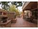 Inviting outdoor space with a built-in fireplace, tile flooring, outdoor dining, and desert views at 18932 N 89Th Way, Scottsdale, AZ 85255