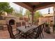 Inviting outdoor space with a built-in fireplace, tile flooring, outdoor dining, and desert views at 18932 N 89Th Way, Scottsdale, AZ 85255