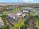 Wide aerial perspective of the home, yard, and green neighborhood beyond at 20216 E Sunset Ct, Queen Creek, AZ 85142