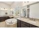 Elegant bathroom featuring a soaking tub, granite countertops, and custom cabinetry at 20216 E Sunset Ct, Queen Creek, AZ 85142