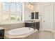 Serene bathroom with soaking tub, tiled surround, and shuttered window at 20216 E Sunset Ct, Queen Creek, AZ 85142