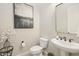 Stylish powder room featuring pedestal sink, decorative mirror, and neutral color palette at 20216 E Sunset Ct, Queen Creek, AZ 85142