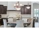 Elegant dining room featuring a decorative chandelier, granite countertops, and dark wood cabinets at 20216 E Sunset Ct, Queen Creek, AZ 85142