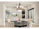 Elegant dining area featuring a stylish chandelier, seating for six, and views into the living area at 20216 E Sunset Ct, Queen Creek, AZ 85142