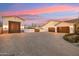 Expansive driveway with multiple garages on a beautifully landscaped lot at sunset at 20216 E Sunset Ct, Queen Creek, AZ 85142