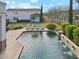 Refreshing pool with lounge chairs, umbrella, and waterfall feature in a lush backyard at 20216 E Sunset Ct, Queen Creek, AZ 85142