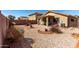 Serene backyard featuring decorative rocks, desert plants, a patio, and block fence at 22569 W Lasso Ln, Buckeye, AZ 85326