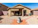 Backyard featuring gravel landscaping, a covered patio area, desert plants, and a charming water feature at 22569 W Lasso Ln, Buckeye, AZ 85326