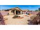 Backyard featuring gravel landscaping, a covered patio, and a privacy wall at 22569 W Lasso Ln, Buckeye, AZ 85326