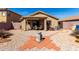 Backyard with gravel, patio area and view of the house with neutral colors at 22569 W Lasso Ln, Buckeye, AZ 85326