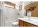 Well-lit bathroom featuring a shower-tub combo with white tile surround and a wooden vanity at 22569 W Lasso Ln, Buckeye, AZ 85326