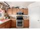 Modern kitchen featuring stainless steel appliances, wood cabinets, tile backsplash and lighting at 22569 W Lasso Ln, Buckeye, AZ 85326