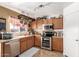 Well-lit kitchen featuring stainless steel appliances, wooden cabinets and tiled countertops at 22569 W Lasso Ln, Buckeye, AZ 85326