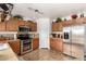 Bright kitchen with stainless steel appliances, wooden cabinets, and access to a breakfast area at 22569 W Lasso Ln, Buckeye, AZ 85326