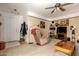 Comfortable living room with cozy armchair, ceiling fan, and neutral carpeting at 22569 W Lasso Ln, Buckeye, AZ 85326