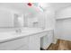 Bright bathroom featuring double sinks with white cabinets and laminate floors at 2331 E Pecan Rd, Phoenix, AZ 85040