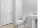 A well-lit bathroom featuring a pedestal sink, tile flooring, and a white toilet at 2331 E Pecan Rd, Phoenix, AZ 85040