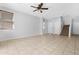 Open-concept living room featuring neutral tile flooring, a ceiling fan, and access to the staircase at 2331 E Pecan Rd, Phoenix, AZ 85040