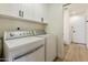 Well-lit laundry room with built-in cabinets and adjacent powder room at 2440 E Hale St, Mesa, AZ 85213