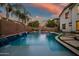 Inviting pool features tiled waterfalls and a tanning ledge, set against lush greenery for a serene outdoor experience at 2484 E Lodgepole Dr, Gilbert, AZ 85298