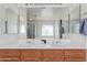 Bathroom featuring double sinks, oak cabinetry, and a large mirror reflecting the shower and tub at 2525 W Sat Nam Way, Phoenix, AZ 85086