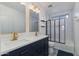 Modern bathroom with double vanity, black and white tiles, and a glass-enclosed shower at 2525 W Sat Nam Way, Phoenix, AZ 85086