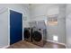 Convenient laundry room with modern washer and dryer, shelving, and a blue door at 2525 W Sat Nam Way, Phoenix, AZ 85086