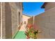 Narrow side yard with vibrant pink bougainvillea against a textured wall under a bright blue sky at 2525 W Sat Nam Way, Phoenix, AZ 85086