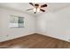 Bright bedroom featuring a ceiling fan, wood-look flooring and a large window for natural light at 2570 W Scenic St, Apache Junction, AZ 85120