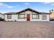 Charming single-story home featuring a red front door and gravel landscaping at 2834 N 65Th Ave, Phoenix, AZ 85035