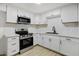 Modern kitchen with stainless steel appliances and white cabinets, with a black faucet at 2834 N 65Th Ave, Phoenix, AZ 85035