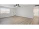 Bright living room featuring new light wood flooring, a ceiling fan, and freshly painted white walls at 2834 N 65Th Ave, Phoenix, AZ 85035