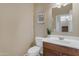 Cozy bathroom with wood vanity, modern art, and decorative plant at 28793 N Spur Dr, San Tan Valley, AZ 85143