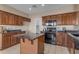 Spacious kitchen features wood cabinets, dark granite counters, and black appliances at 28793 N Spur Dr, San Tan Valley, AZ 85143