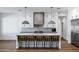 Elegant kitchen island featuring pendant lighting, seating, and a view of modern appliances and cabinetry at 2964 E Palo Verde St, Gilbert, AZ 85296