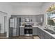 Well-lit kitchen featuring stainless steel appliances and grey cabinetry with wood floors at 3018 W Matthew Dr, Phoenix, AZ 85027